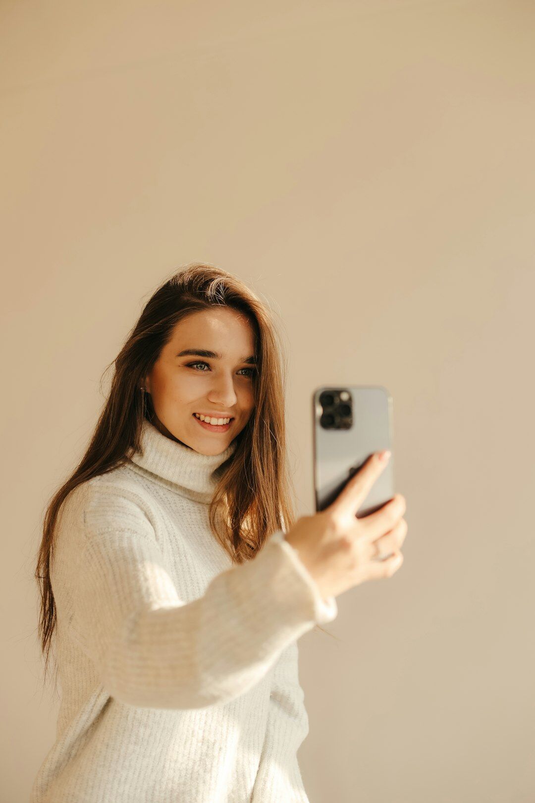 Young woman smiling while filming herself with a smartphone