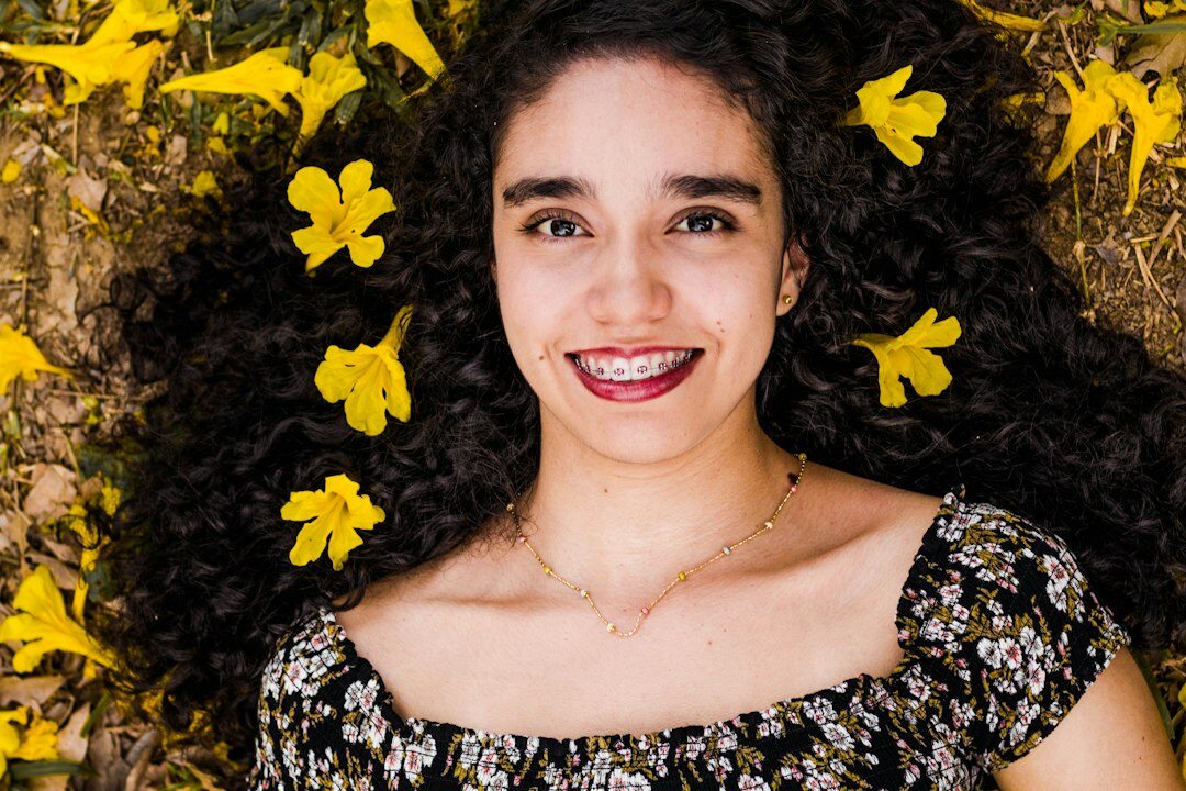 Professional portrait of a young woman with curly hair smiling
